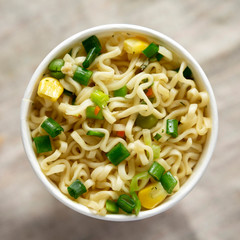 Top view, tasty instant noodles with beef flavoring in a cup. Flat lay, from above, overhead. Close-up.