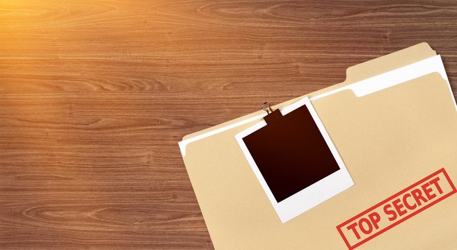 A manila folder with the faded words Top Secret on the front, isolated on background