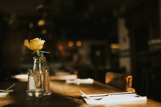 A close up shot of a romantic dinner set up with glassware and a flower. Concept of restaurant business, catering and hospitality. Horizontal image with free copy space for your text.
