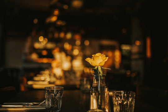 A close up shot of a romantic dinner set up with glassware and a flower. Concept of restaurant business, catering and hospitality. Horizontal image with free copy space for your text.