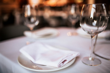 A close up shot of a restaurant table set up with tableware and wine glass. Concept of dining, hospitality and catering. Horizontal image with free space for text.