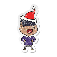 distressed sticker cartoon of a happy boy laughing wearing santa hat