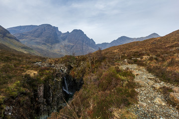On the way to the Bla Bheinn mountain with a water fall and a majestic rocky mountain