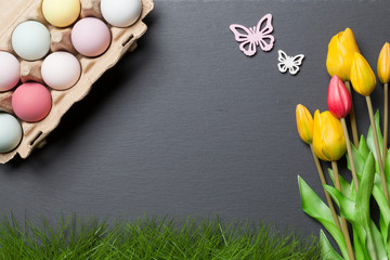 Frohe Ostern Hintergrund mit Eierkarton, bunten Ostereiern und Blumen © pixelliebe