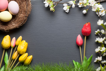 Frohe Ostern Hintergrund mit Osternest, bunten Ostereiern und Blumen