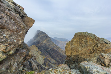 A rocky mountain view with altitude white clouds