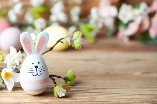 Osterhase mit bunten Ostereiern und Blumen