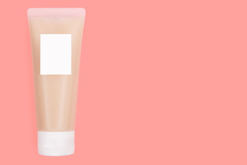Transparent Plastic Packaging - Tube With White Lid Filled With Beige Cream And Mockup Label On Pale Pink Or Living Coral Background.