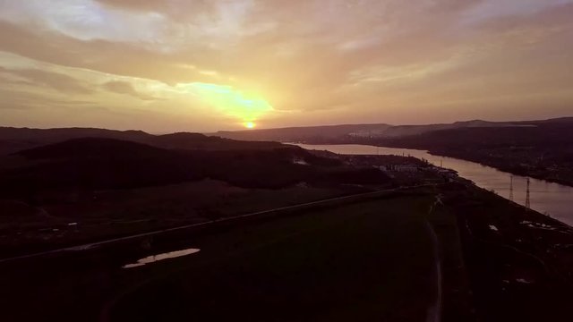 Ascending aerial view of sunset near river and landscape