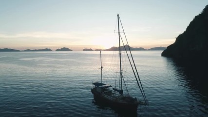 Aerial drone view of boats anchored in the bay with clear and turquoise water on the sunset. Boat and yacht in the tropical lagoon. Tropical landscape. El Nido, Palawan island, Philippines.