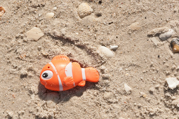 top view, close up of an orange, plastic fishing lore on a sandy, tropical beach on the gulf of mexico on a sunny, winter day