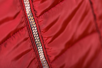 Close up of zipper on red jacket , winter fashion outfit. Jacket isolated on white background.