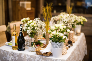 Wedding table in the restaurant decorated with flowers in rustic style