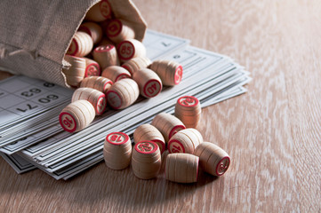 Board game lotto. Cards for the game of lotto on them wooden barrels spilled out of the bag. Group entertainment, family vacation. Vintage game. Passion and luck. Close-up.