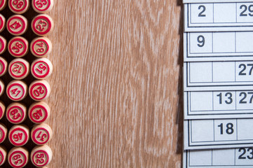 Fototapeta premium Board game lotto. Wooden table. On the right are cards for the game, on the left along the edge of the picture are the kegs. Excitement and good luck. Group entertainment, family leisure.