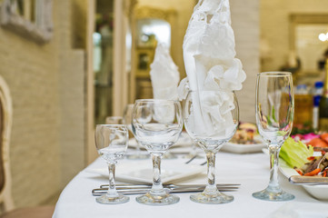 Served table with plates, white napkins, and glasses, dinner in the restaurant