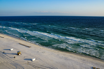 Aerial view of an empty Panama City Florida beach on a beautiful clear blue skies and emerald green and blue water.