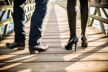 chic couple walking on bridge with cowboy boots and high heels