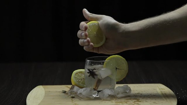 Squeezing lemon juice into a glass. Fornt view.