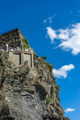 Naklejka premium Italy, Cinque Terre, Vernazza, a large stone building with a mountain in the background