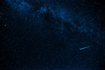 shooting star in background a starry blue dark sky