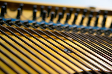 Bass strings strung in the old piano. The mechanism of musical instruments