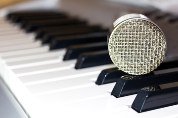 Silver microphone on the keyboard synthesizer
