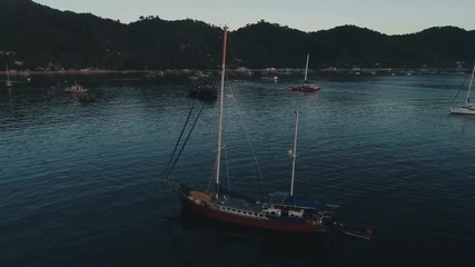 Aerial drone view of boats anchored in the bay with clear and turquoise water on the sunset. Boat and yacht in the tropical lagoon. Tropical landscape. El Nido, Palawan island, Philippines.