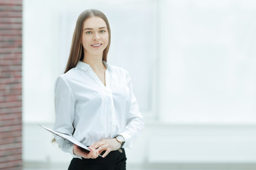 Fototapeta premium Executive business woman with clipboard against the background of bright office