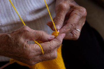 Hands of an old woman knitting needles