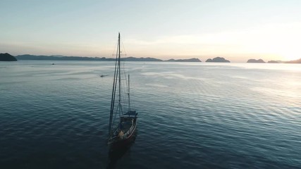 Aerial drone view of boats anchored in the bay with clear and turquoise water on the sunset. Boat and yacht in the tropical lagoon. Tropical landscape. El Nido, Palawan island, Philippines.