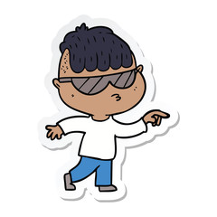 sticker of a cartoon boy wearing sunglasses pointing