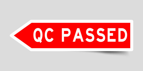 Arrow shape red color sticker in word QC (abbreviation of quality control) passed on gray background