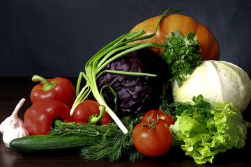 Still life of fresh vegetables. Pumpkin, white cabbage, red cabbage, two tomatoes, large and juicy red sweet peppers, greens of Basil, dill, parsley and green onions, as well as green fresh cucumber a