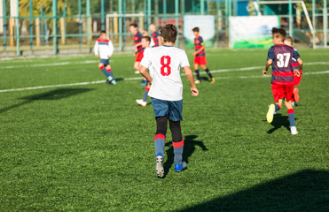 Obraz premium Football training soccer for kids. Boy runs kicks dribbles soccer balls. Young footballers dribble and kick football ball in game. Training, active lifestyle, sport, children activity concept 