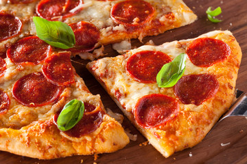 Close-up of a Slice of  Pepperoni Pizza with Fresh Basil
