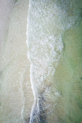 Waves crashing on beach drone aerial