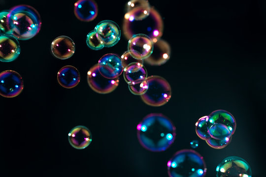 colorful soap bubbles floating in the dark.
