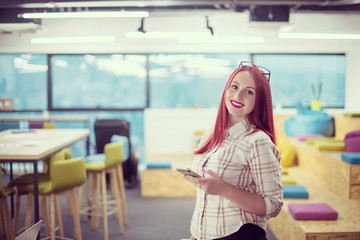 redhead businesswoman using mobile phone at office