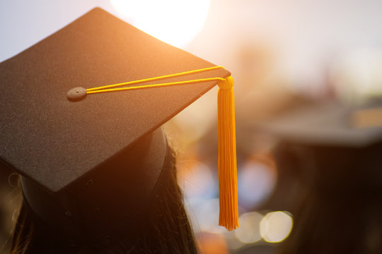 Rear view selective focus of the university graduates crowded in the graduation ceremony. The graduates stand in-line while waiting for  awarding degree certificate. Graduation congratulations
