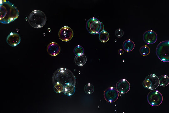 Beautiful colorful soap bubbles floating in the dark.