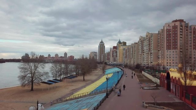 Obolon quay with dnipro river on background and Ukrainian flag