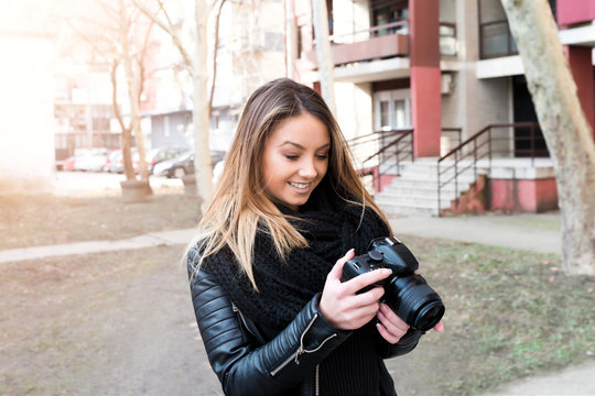 Young girl holding camera outside
