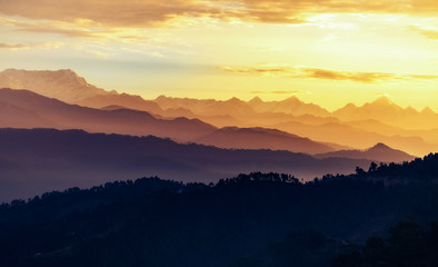 Fototapeta na wymiar Barren Himalaya mountain ranges at sunrise with moody vibrant sky at Kausani Uttarakhand.