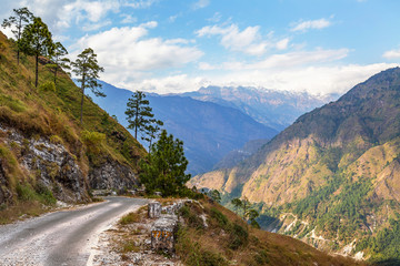 Scenic mountain road with distant Himalaya snow peaks and mountain valley near Kausani Uttarakhand India