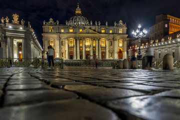 Obraz premium Vatican City,Italy - 23 June 2018: St.Peters Basilica is illuminated with lights at night in Vatican city in the square with moonlight at night