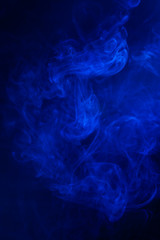 Blue smoke on black background.