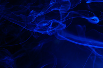 Blue smoke on black background.