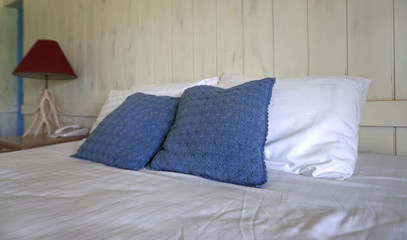 Comfortable throw cushion on white pillows on the bed