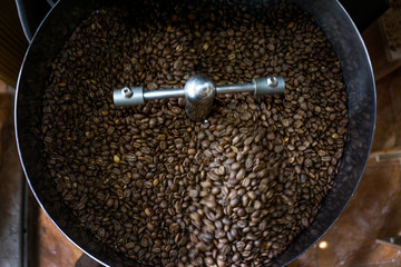 Freshly roasted aromatic Coffee beans in modern coffee roasting machine.